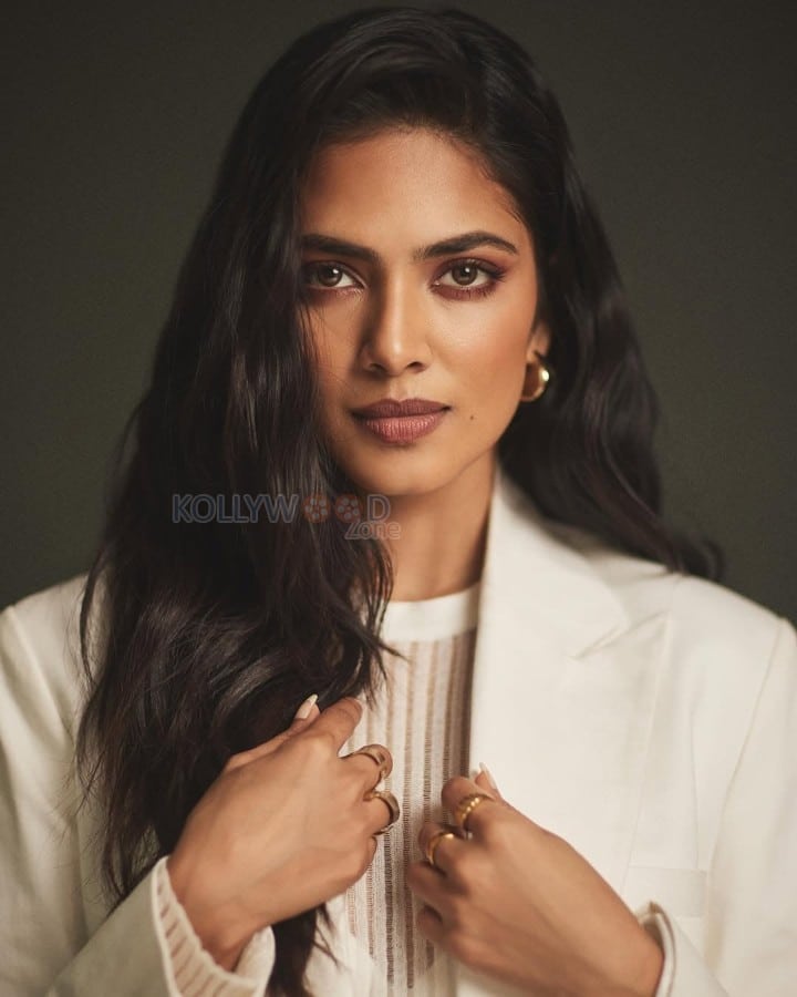 Beautiful Malavika Mohanan in an Off White Bralette with a See Through Top and Trench Coat with White Pants Photos 04