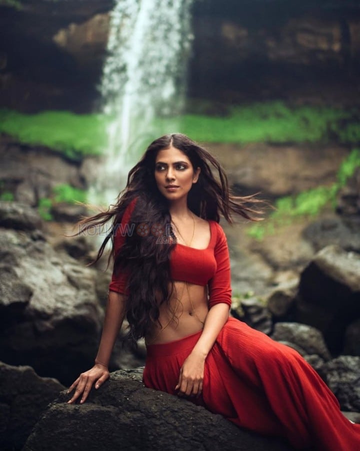 Sensuous Malavika Mohanan in a Bold Red Blouse with Matching Red Skirt Standing in Front of a Waterfall Photoshoot Pictures 03