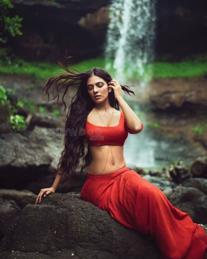 Sensuous Malavika Mohanan in a Bold Red Blouse with Matching Red Skirt Standing in Front of a Waterfall Photoshoot Pictures 04