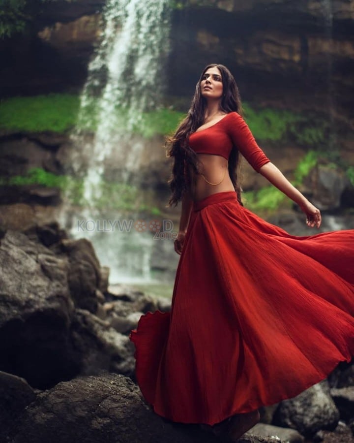 Sensuous Malavika Mohanan in a Bold Red Blouse with Matching Red Skirt Standing in Front of a Waterfall Photoshoot Pictures 05