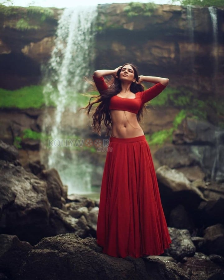 Sensuous Malavika Mohanan in a Bold Red Blouse with Matching Red Skirt Standing in Front of a Waterfall Photoshoot Pictures 06