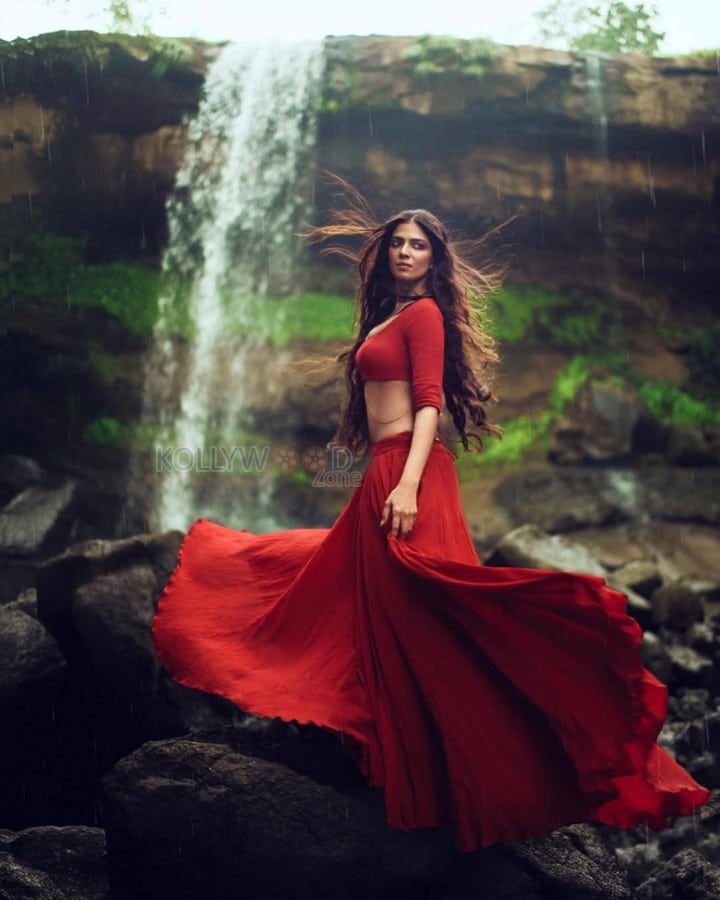 Sensuous Malavika Mohanan in a Bold Red Blouse with Matching Red Skirt Standing in Front of a Waterfall Photoshoot Pictures 07