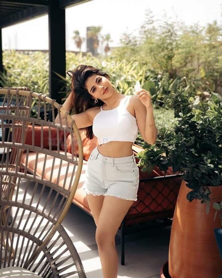 Elegant and Sexy Iswarya Menon in a White Tank Top and Denim Shorts Photos 04