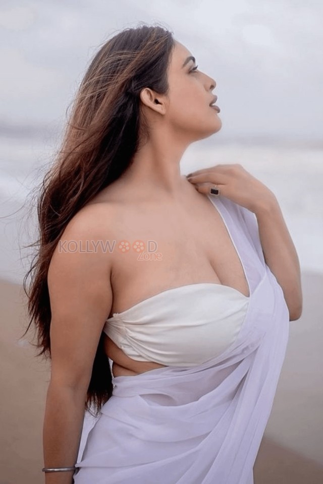 Bold Neha Malik in a White Saree with Sleeveless Blouse on the Beach Photos 02