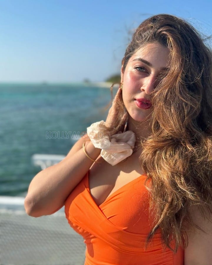 Spellbinding Sonarika Bhadoria in a Sleeveless Orange Top with White Pants Photos 01