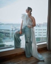 Breathtaking Tamannaah Bhatia in a Ruffled One Shoulder White Top with Ripped Denim Jeans Photos 06