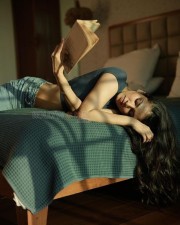 Sensual Malavika Mohanan in a Black Turtle Neck Top with Classic Blue Denim Lying on the Bed Photos 06