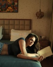 Sensual Malavika Mohanan in a Black Turtle Neck Top with Classic Blue Denim Lying on the Bed Photos 08