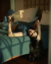 Sensual Malavika Mohanan in a Black Turtle Neck Top with Classic Blue Denim Lying on the Bed Photos 09