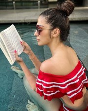 Stunning Raai Laxmi Reading in a Red Swimsuit Photos 02