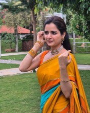 Beautiful Ashika Ranganath in a Vibrant Orange Saree with a Sleeveless Blouse Photos 03